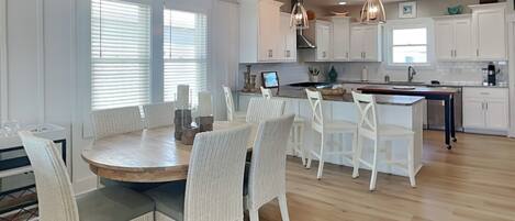 A modern kitchen with white cabinetry, a central island, and pendant lighting.