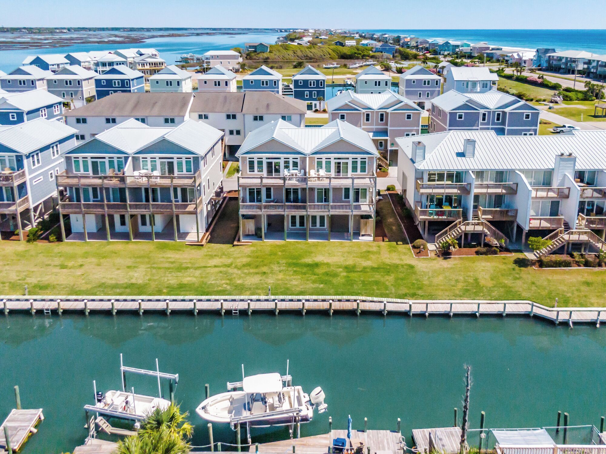 A coastal residential area with multiple two-story houses featuring balconies and a marina with boats.