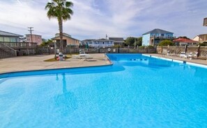 A swimming pool with a palm tree and lounge chairs. - Queens Grant by Topsail Realty (Holly Ridge)