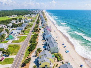 A coastal residential area with houses along the beach, a road, and ocean views. - Ocean Dunes by Carolina Retreats (Kure Beach)