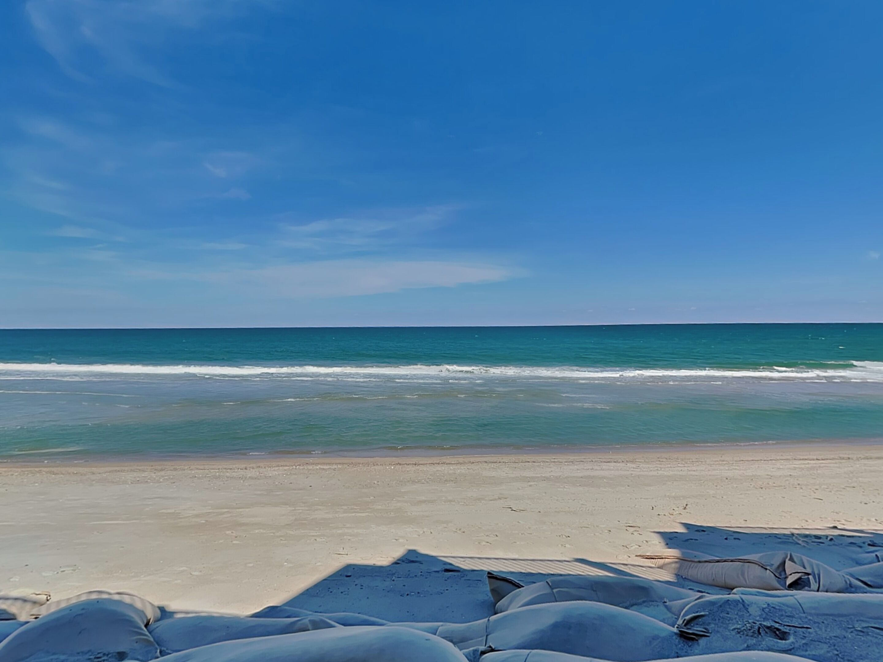A beach with sand and ocean waves.
