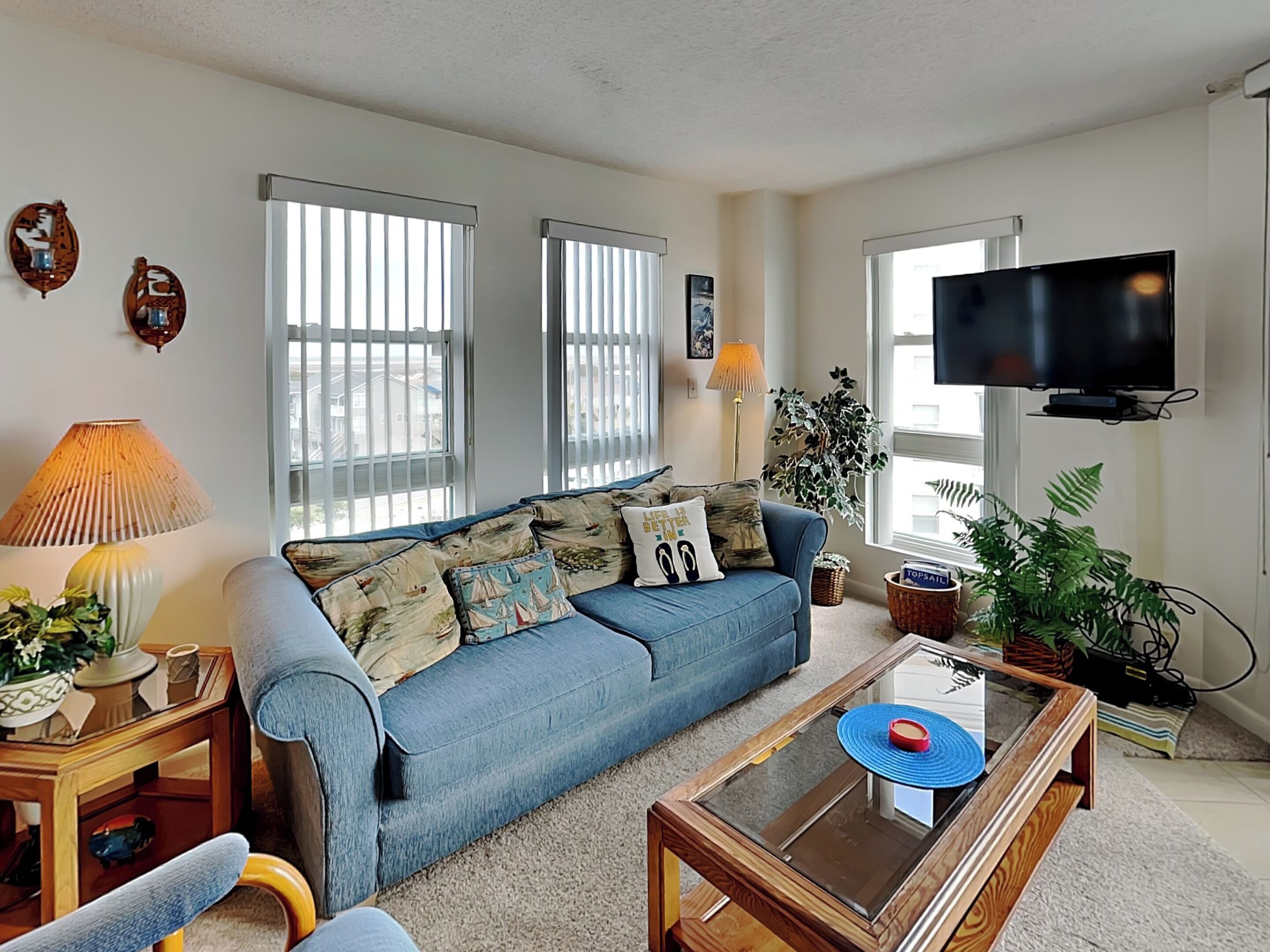 A living room with a sofa, a coffee table, a TV, and a lamp.