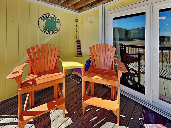 A wooden deck with two Adirondack chairs, a small table, and a sign reading "Paradise Found". - Surf Condos by Topsail Realty (Holly Ridge)