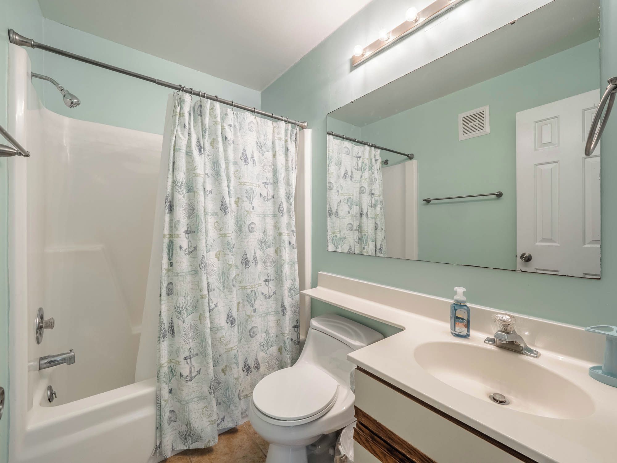 A bathroom with a shower, toilet, and sink.