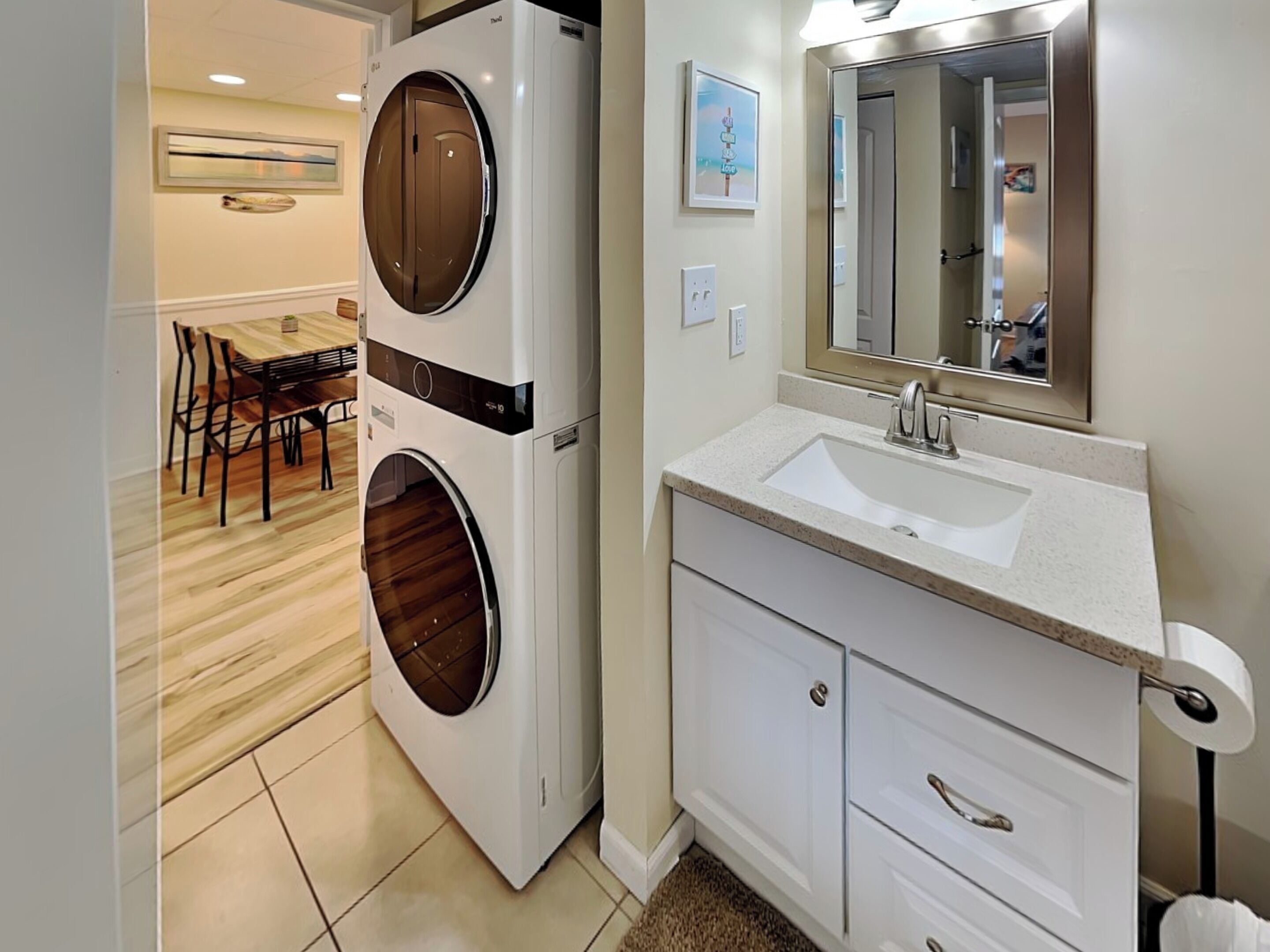 A modern bathroom with a built-in washer and dryer, a sink, and a mirror.