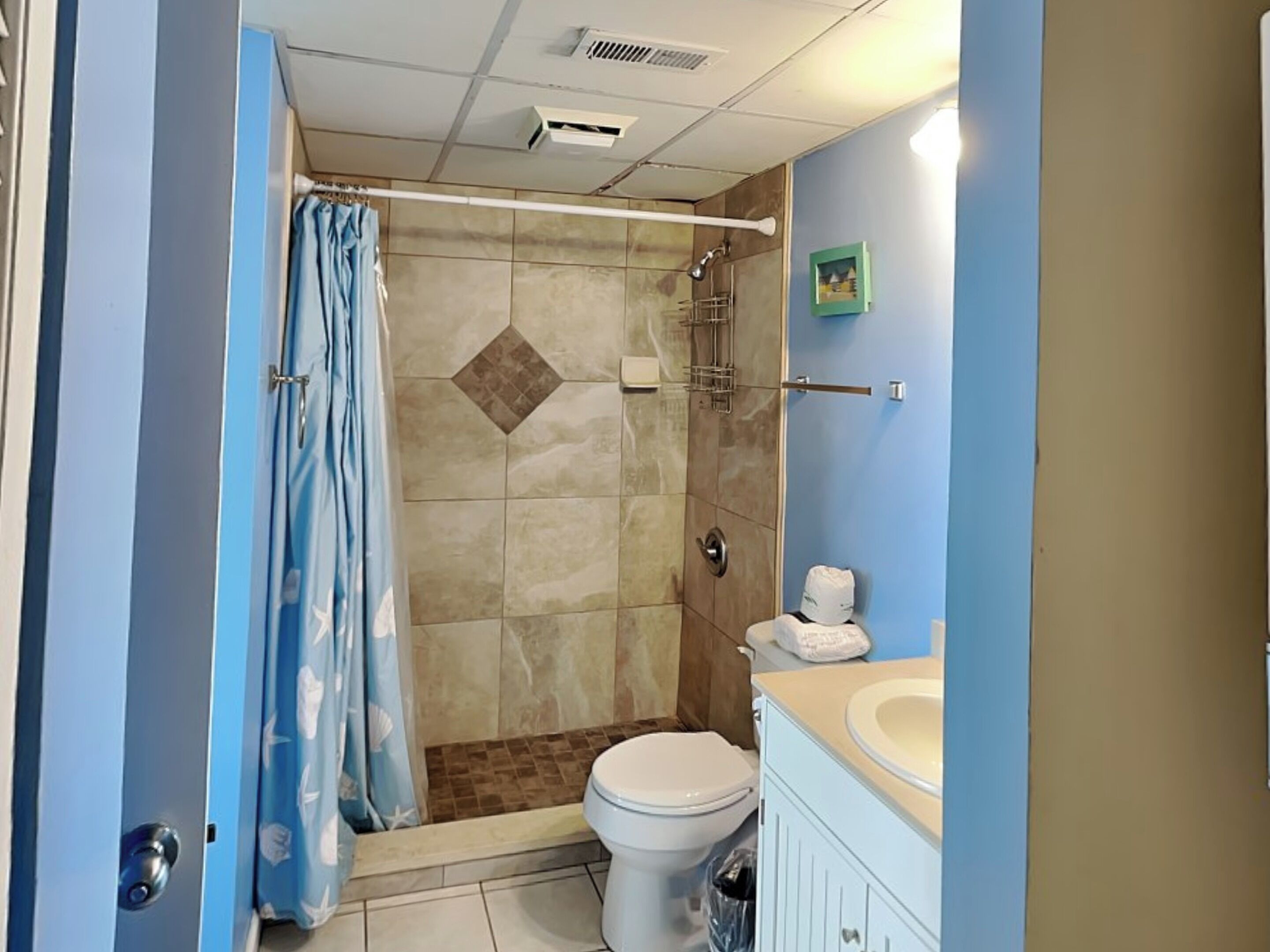 Un baño con ducha, inodoro y lavamanos.