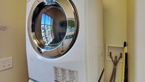 A front-loading LG washer with a circular door, a control panel, and a label with care instructions. - CB Seabee #2 by Carolina Retreats (Carolina Beach)