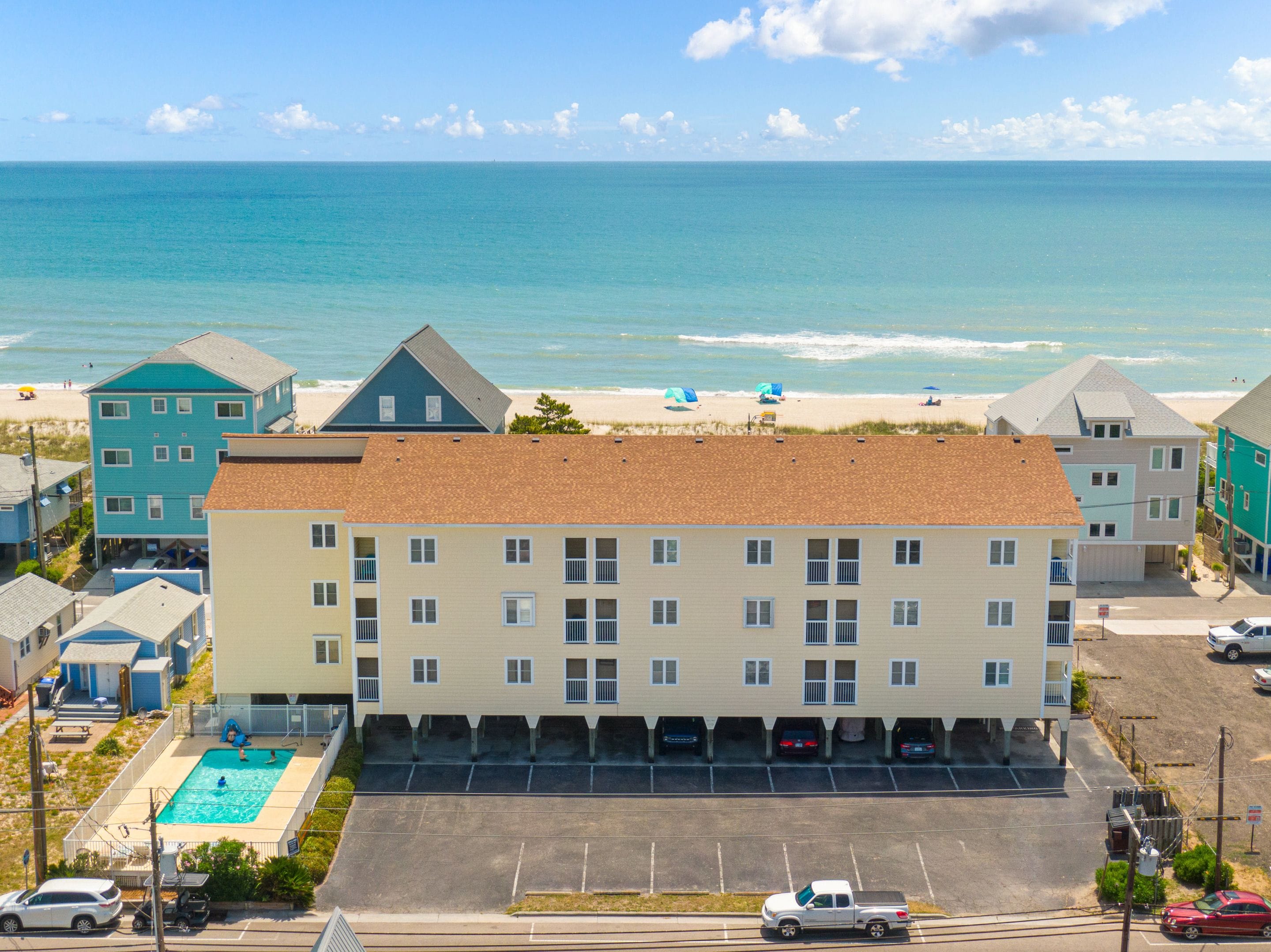 Un hôtel à plusieurs étages doté d’une piscine, d’un parking et offrant une vue sur la plage.