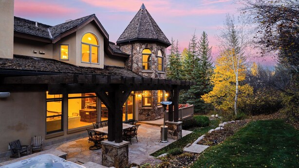 A large house with a stone tower, a patio with outdoor seating, and a well-maintained garden. - Cozy Edwards Retreat w/ Fireplace, Near Ski Resort Osprey Nest by Avantstay (Edwards)
