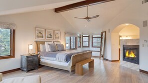 A spacious bedroom with a large bed, a wooden bench, a fireplace, and multiple windows. - Cozy Edwards Retreat w/ Fireplace, Near Ski Resort Osprey Nest by Avantstay (Edwards)