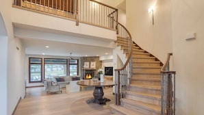 A spacious living area with a wooden staircase, a fireplace, and a dining table. - Cozy Edwards Retreat w/ Fireplace, Near Ski Resort Osprey Nest by Avantstay (Edwards)