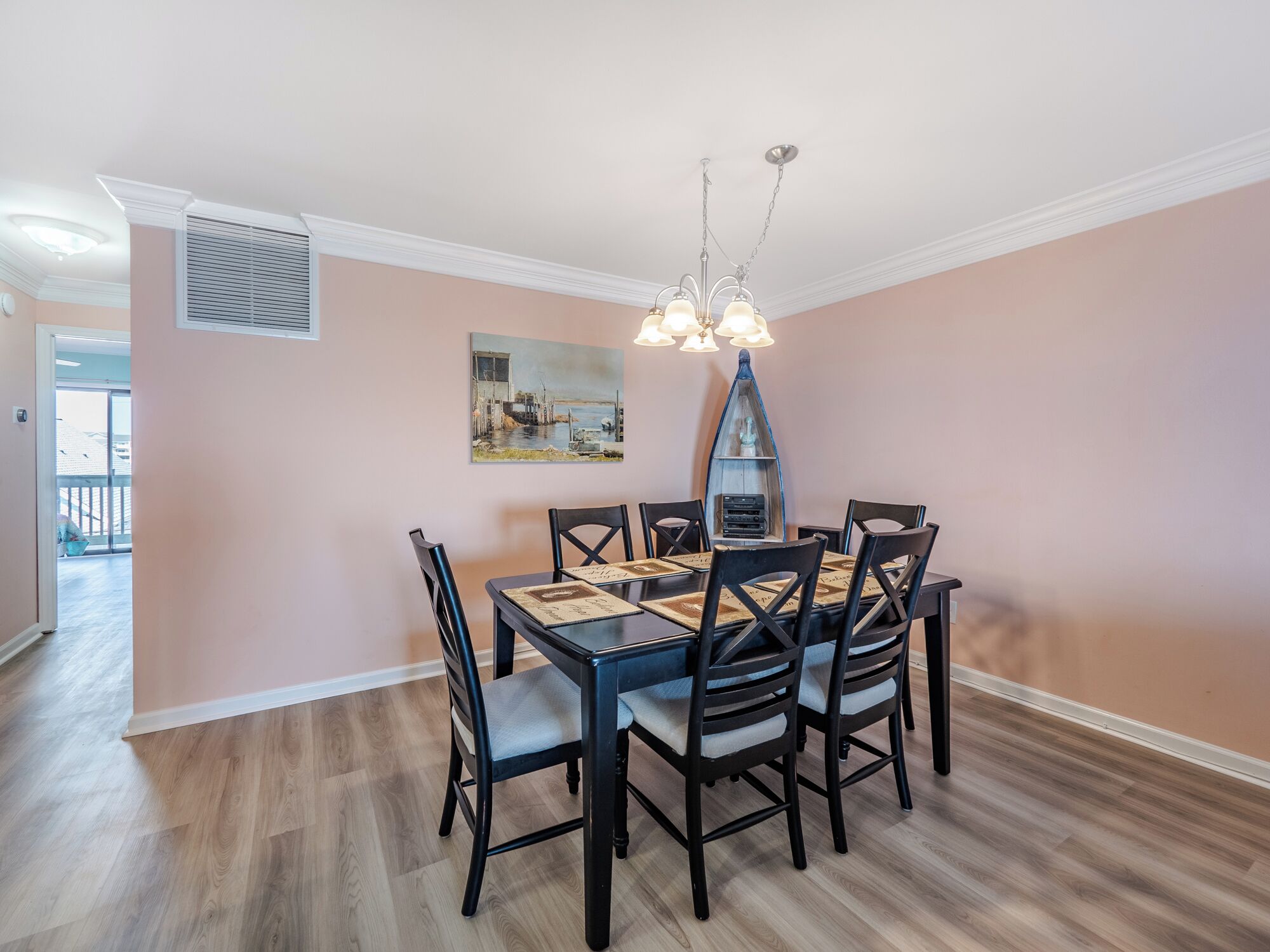 Un coin repas avec une table dressée pour six personnes, entourée de chaises.