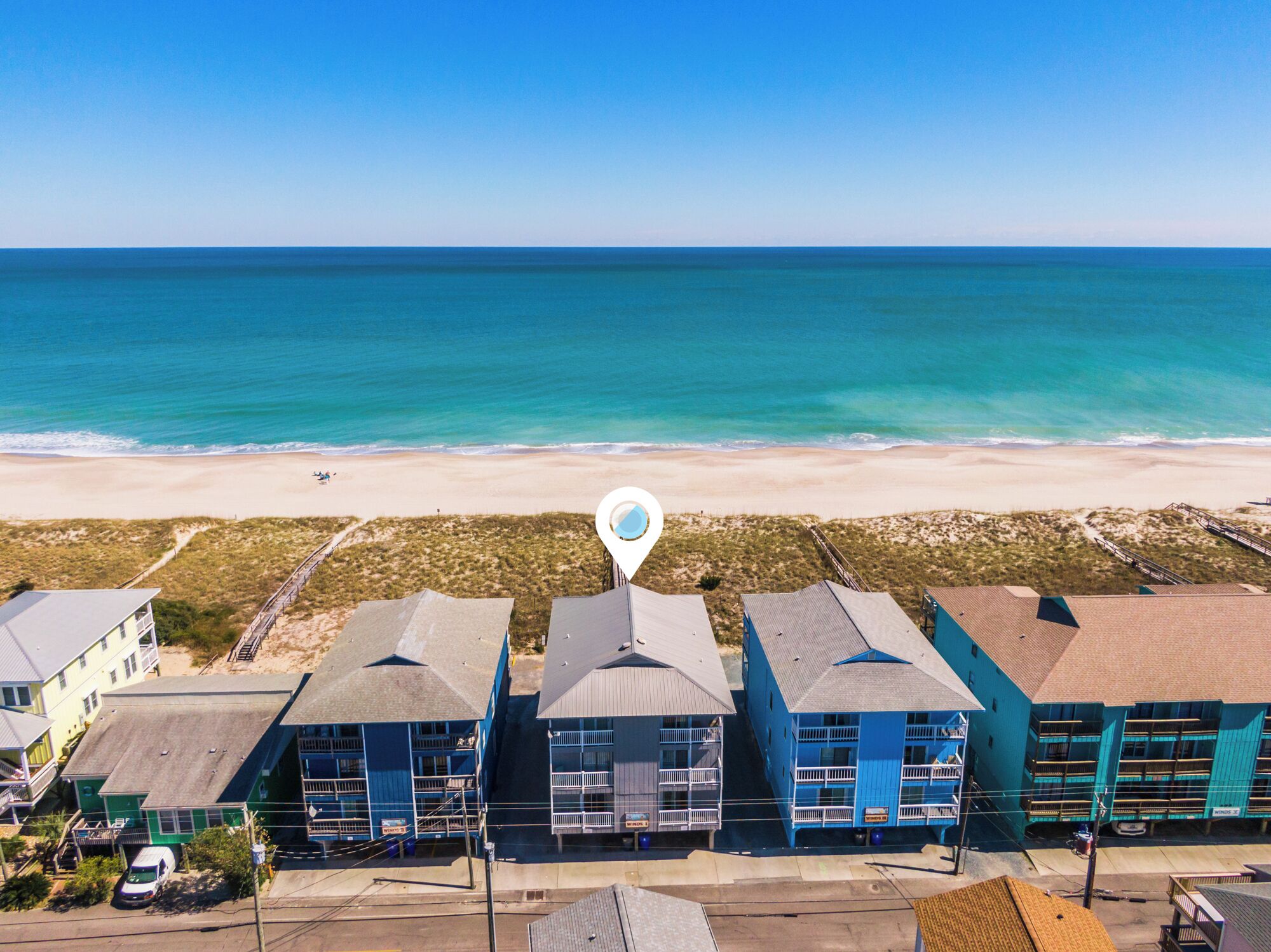 A beachfront hotel with multiple buildings, a beach view, and a lifeguard tower.