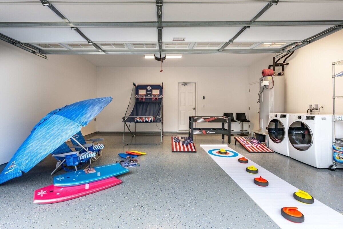 A garage with a ping pong table, a sled, and a curling rink.