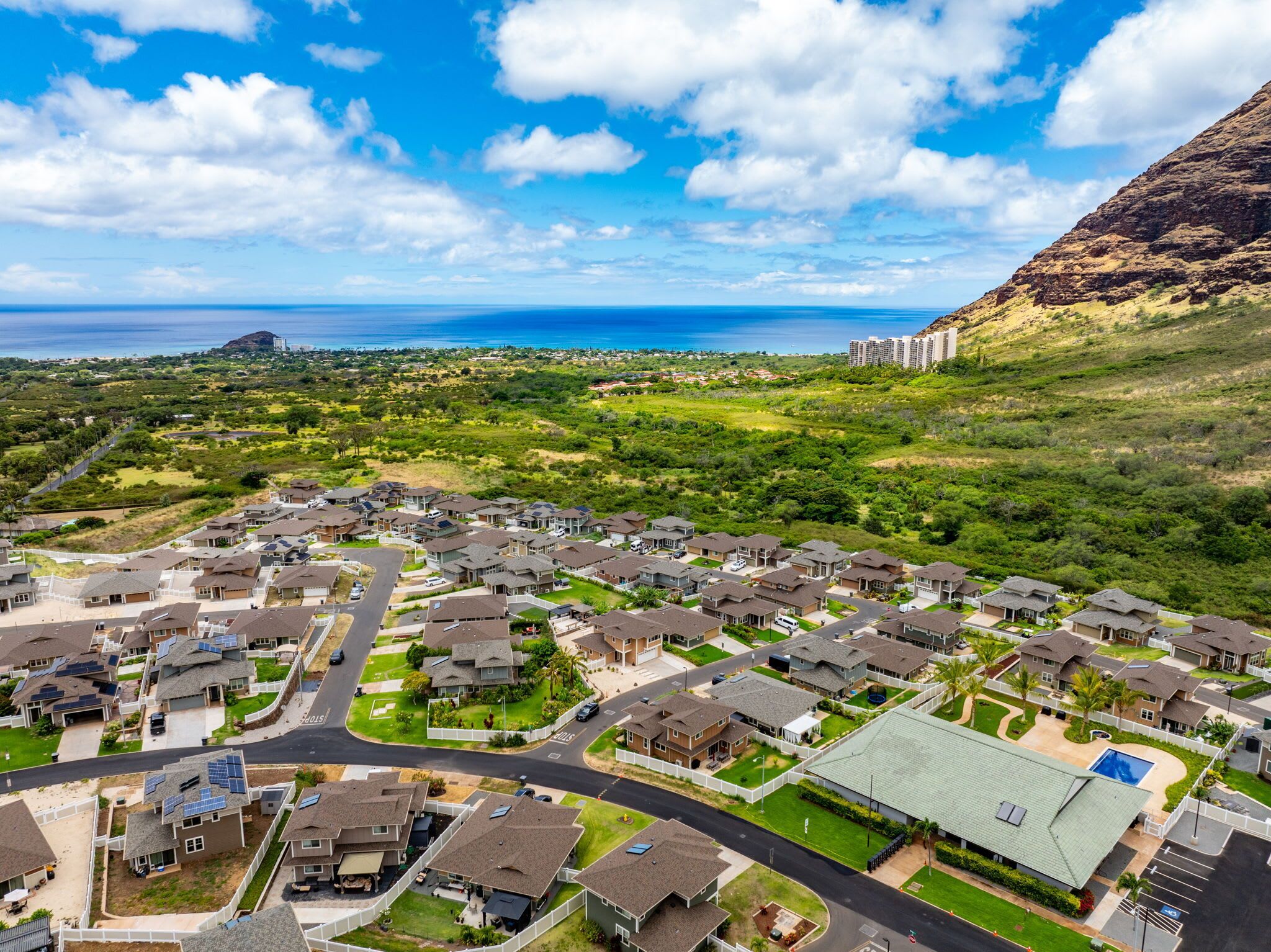 A residential area with houses, roads, and a large mountain in the background.