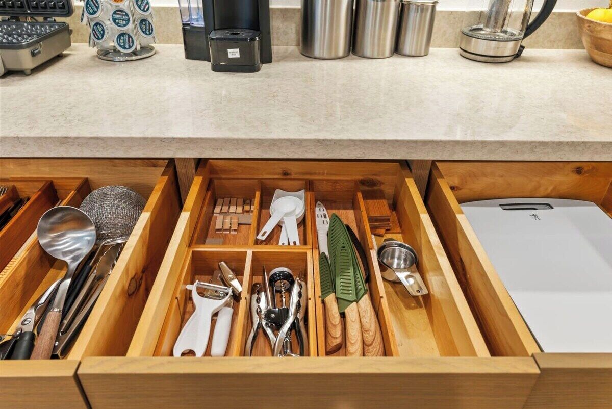 Un cassetto della cucina con diversi utensili e accessori.