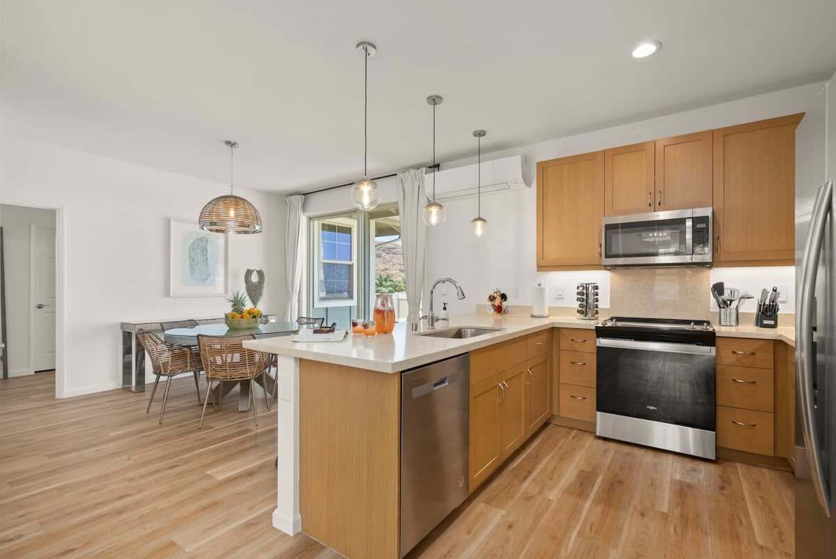 A modern kitchen with wooden cabinets, stainless steel appliances, and a central island.