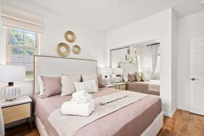 Ein Hotelzimmer mit einem großen Bett, einem Nachttisch mit Lampe und einem Spiegel an der Wand.