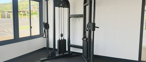A gym with a pull-up bar, weight stack, and a bench.