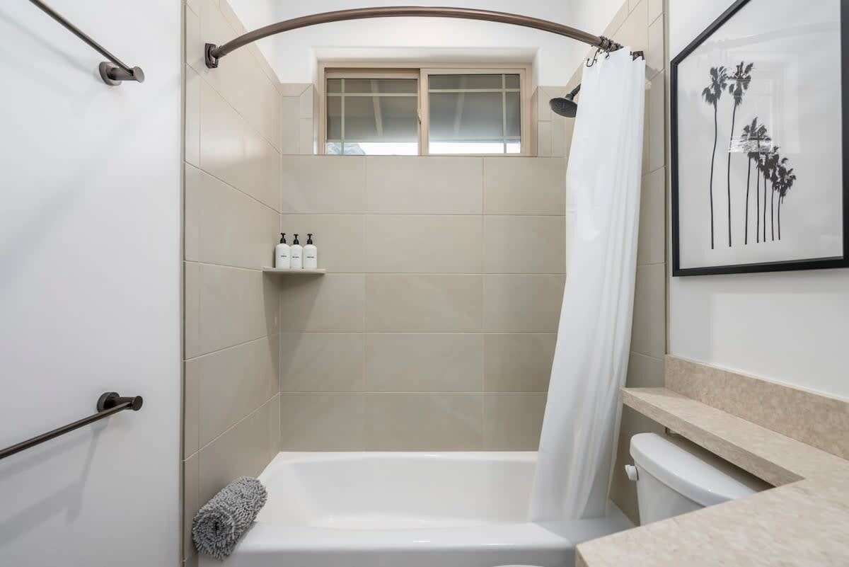 A modern bathroom with a walk-in shower, a toilet, and a sink.