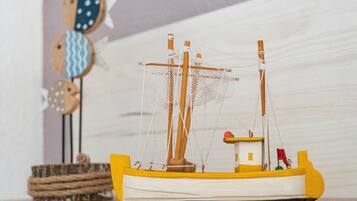 A model ship with a yellow hull and white deck, a small cabin, and a net.