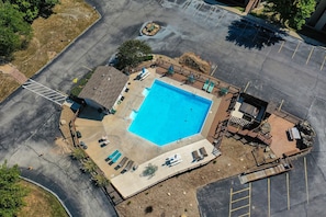 An aerial view of a swimming pool area with a deck, lounge chairs, and a barbecue area. - NO STEPS #6 Lakeview Top Floor Blue Sky Escape (Branson)