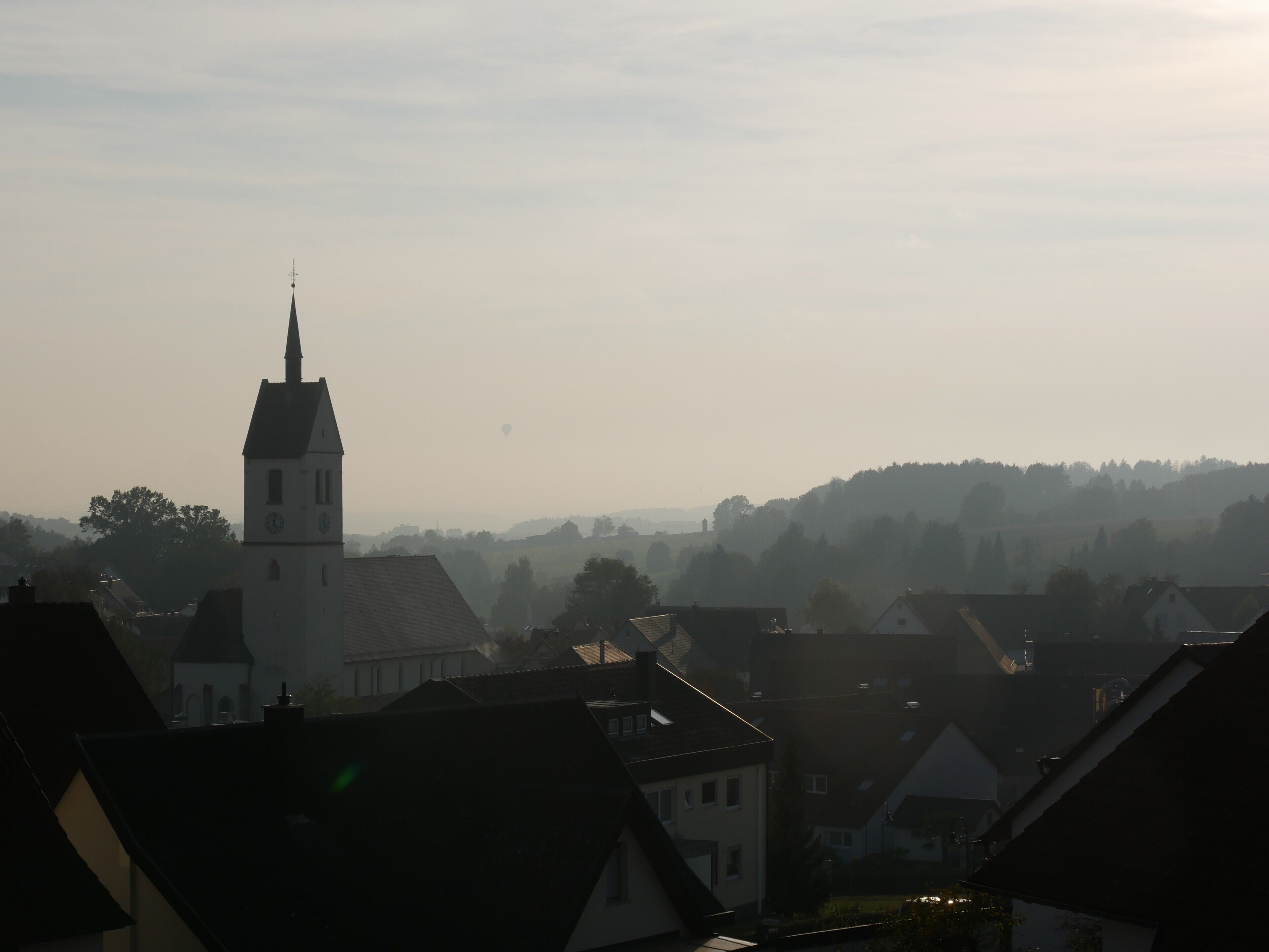 Une église dotée d’un clocher imposant, entourée d’immeubles d’habitation.