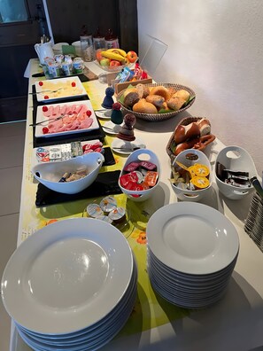 Una mesa de buffet con diversos alimentos y salsas.