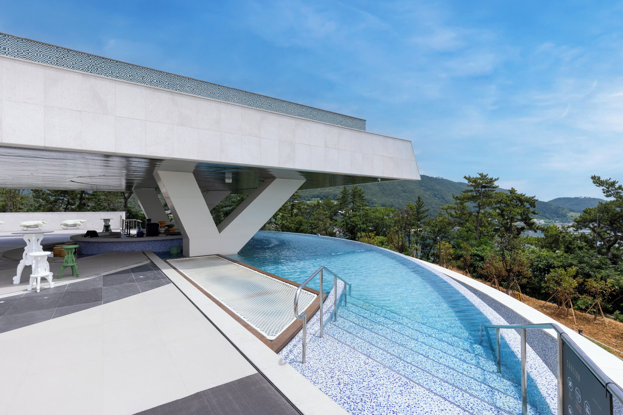 A modern infinity pool with a clear view of the mountains in the background.