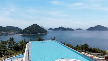 A rooftop infinity pool with a view of the sea and islands.