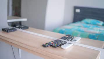 Un escritorio de madera con varios controles remotos y un cable blanco.
