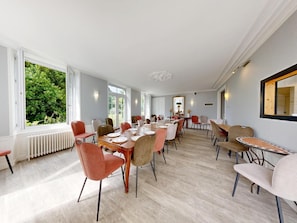 A spacious dining area with multiple tables and chairs, large windows with a view of greenery, and a modern ceiling design. - Clos Minotte 30 pers 2 Cottage : jacuzzi, billards, baby-foot (Tessy-Bocage)
