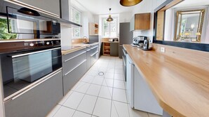 A modern kitchen with a built-in oven, microwave, and coffee maker.