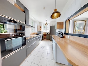 A modern kitchen with a built-in oven, microwave, and coffee maker. - Clos Minotte 30 pers 2 Cottage : jacuzzi, billards, baby-foot (Tessy-Bocage)