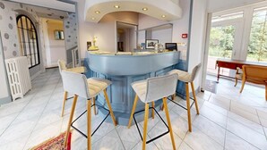 A modern kitchen with a central island, bar stools, and a dining area with a wooden table.