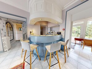 A modern kitchen with a central island, bar stools, and a dining area with a wooden table.