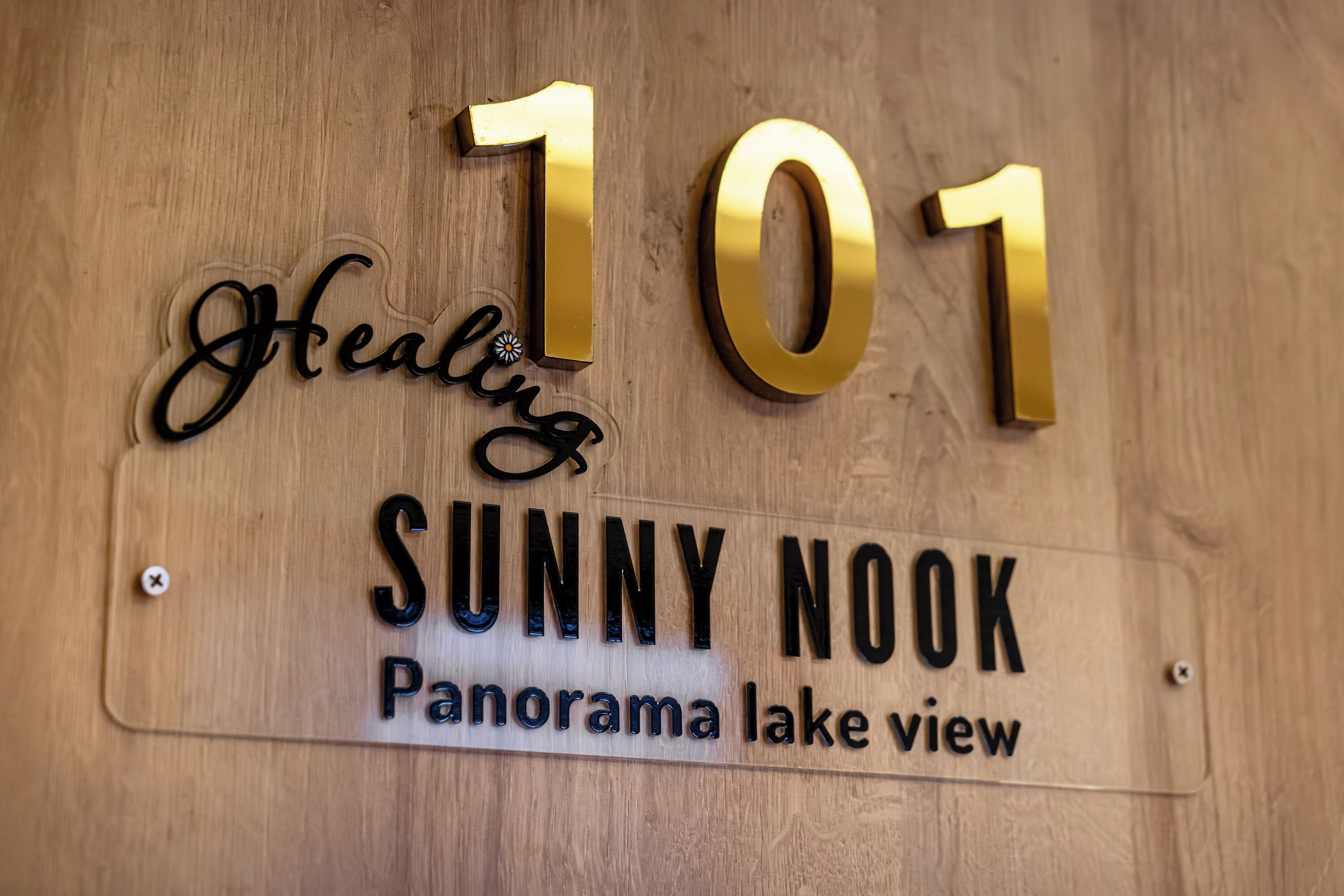 Et træskilt med nummer 101 og ordene "Healing" og "Sunny Nook", der angiver en placering.