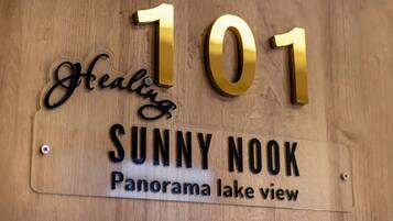Et træskilt med nummer 101 og ordene "Healing" og "Sunny Nook", der angiver en placering.