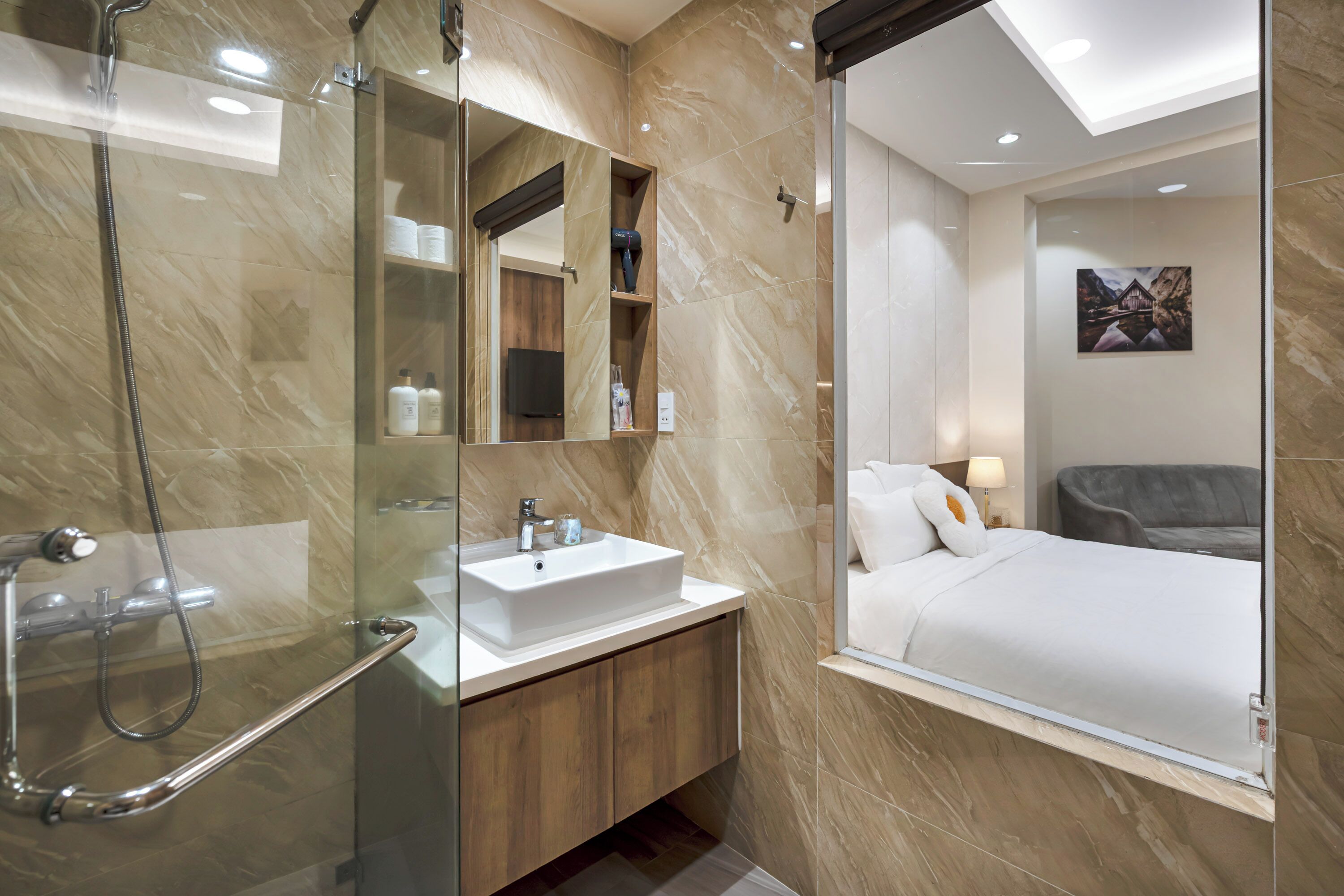 A modern bathroom with a glass-enclosed shower, a white sink, and a wooden vanity.