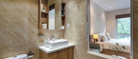 A modern bathroom with a marble sink, wooden vanity, and a large mirror.