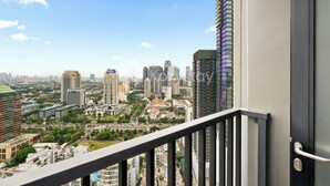 A cityscape with high-rise buildings, a clear sky, and a balcony railing. - Sano by Kozystay - Sudirman (Jakarta)