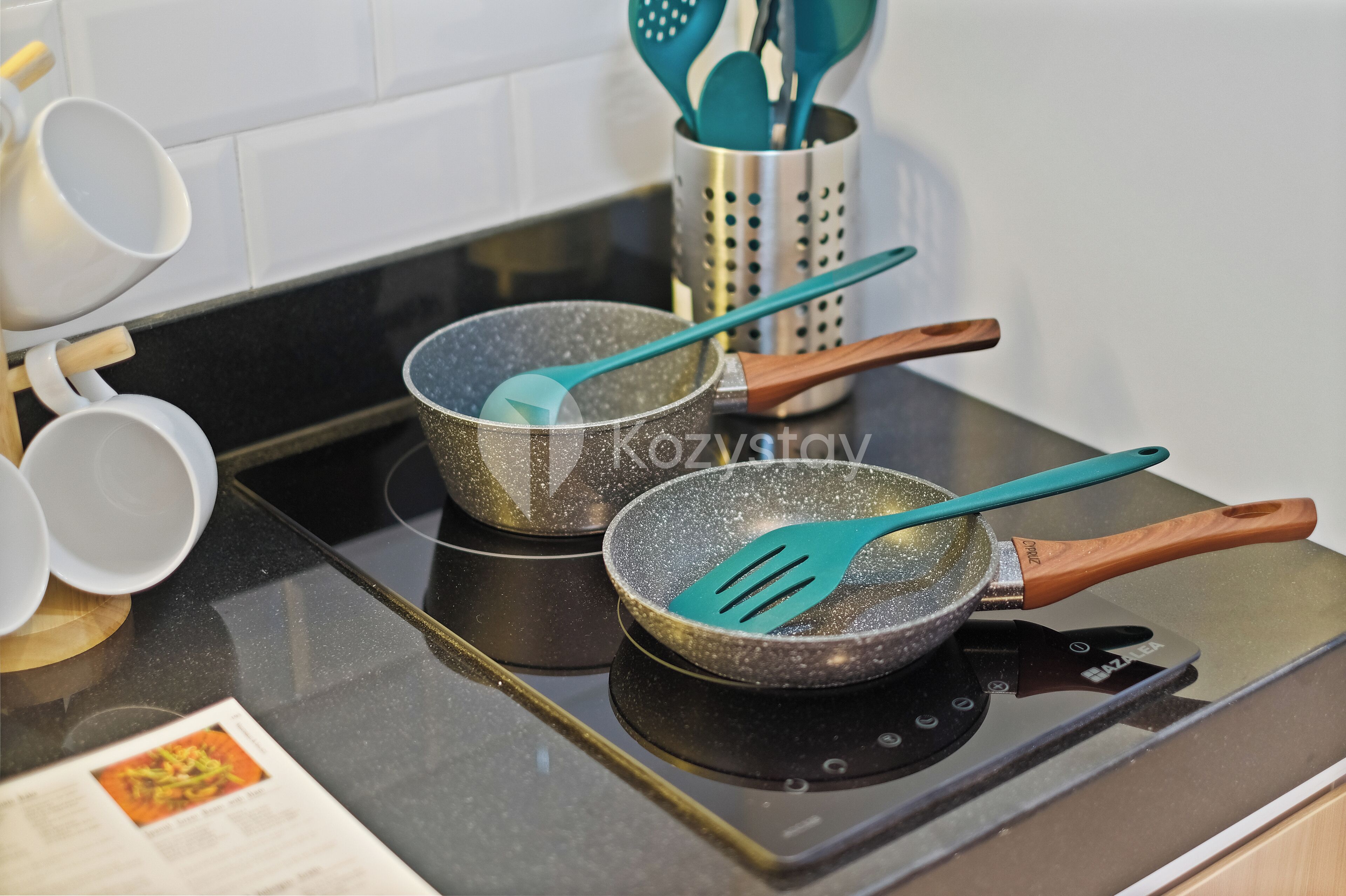 Twee koekenpannen met houten handgrepen op een fornuis.