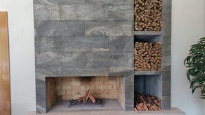 A stone fireplace with three shelves for wood storage. - Quinta Esmeralda (Santiago,)