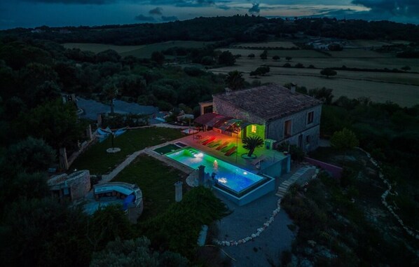 Una villa con piscina, jardín y vistas del campo circundante.