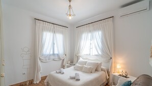 A bedroom with a bed, two bedside tables, a nightstand, a lamp, and a wardrobe. - Holiday Home 'Pozo Viejo' with Private Pool, Wi-Fi and Air Conditioning (Marchena)