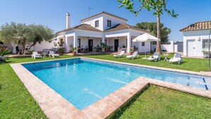 A poolside view of a two-story house with a swimming pool, white exterior, and a clear blue sky. - Holiday Home 'Pozo Viejo' with Private Pool, Wi-Fi and Air Conditioning (Marchena)