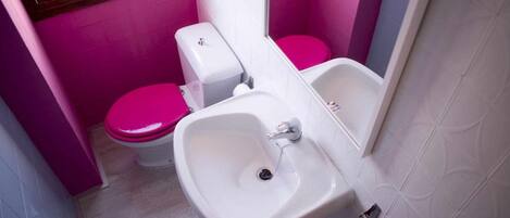 Un baño con bidé, inodoro y lavamanos.