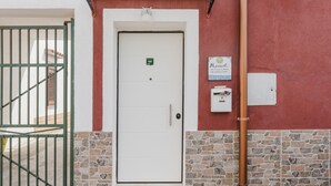 A building with a white door, a green gate, and a stone wall. - Apartment 'Maresol' with Private Terrace, Wi-Fi and Air Conditioning (Marsala)
