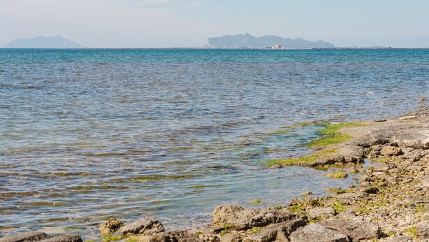 A coastal view with rocky shoreline, calm sea, distant mountains, and a clear sky. - Apartment 'Maresol' with Private Terrace, Wi-Fi and Air Conditioning (Marsala)