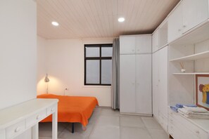 A room with a bed, a desk, a wardrobe, and a window.
